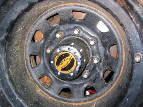 1979 Ford Bronco - Close-up of a Warn locking hub on a black wheel.