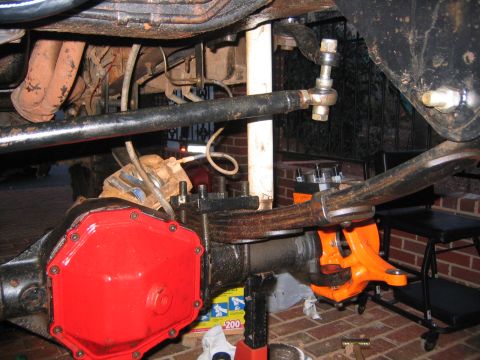 1979 Ford Bronco - Close-up of a vehicle's rear axle and suspension system, showing parts of the drivetrain and steering linkage.