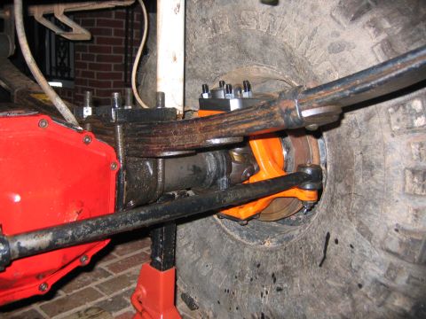 1979 Ford Bronco - Front axle and suspension parts are visible, including an orange axle housing and a red differential cover.