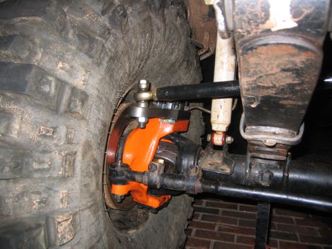 1979 Ford Bronco - Off-road vehicle front axle components, including differential, steering linkage, and suspension, with a large tire visible.