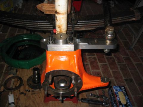 1979 Ford Bronco - Truck spindle assembly with leaf spring and shock absorber, parts on the floor.