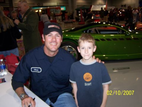 1979 Ford F-150 - A custom green car with black racing stripes is displayed at an indoor event.