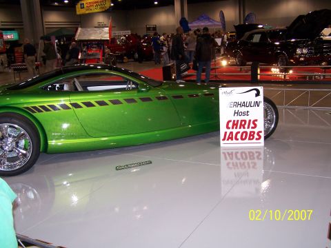 1979 Ford F-150 - A custom green concept car is displayed indoors next to a sign for Chris Jacobs.