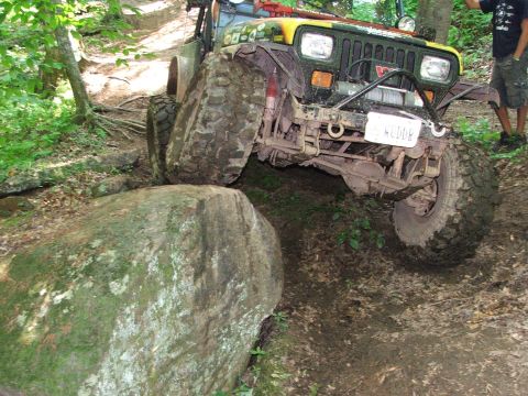 1996 Ford Bronco - Off-road vehicle navigates a challenging rocky terrain with one tire elevated.
