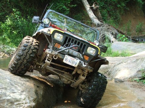 1996 Ford Bronco - This modified Jeep Wrangler TJ navigates a rocky stream bed, its off-road capabilities.