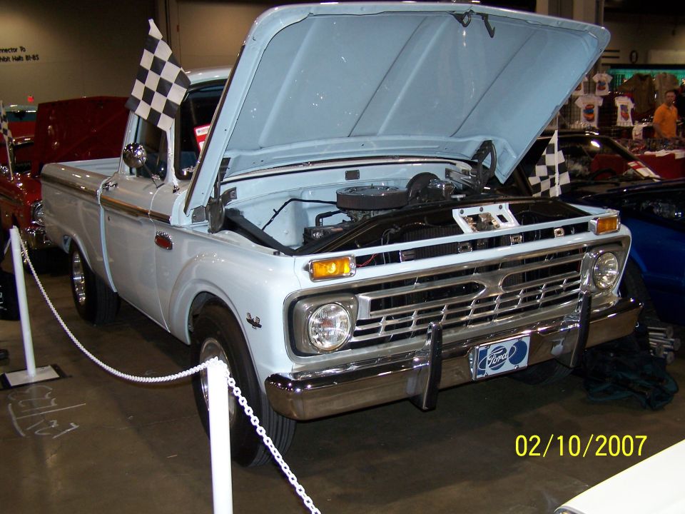 Light blue Ford pickup with hood open, checkered flags, and a date stamp of 02/10/2007