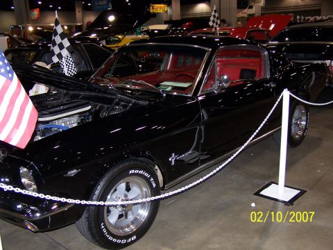 1979 Ford F-150 - A black classic coupe with a red interior is displayed indoors, adorned with a checkered flag.