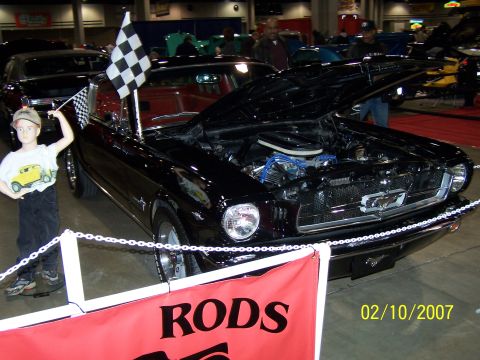 1979 Ford F-150 - Black 1965 Ford Mustang displayed with hood open and checkered flags.