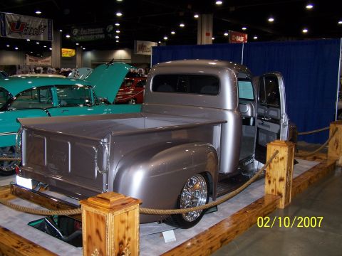 1979 Ford F-150 - A customized pickup truck is displayed indoors next to other classic vehicles.