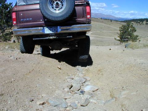 1979 Ford Bronco - This 1979 Ford Bronco is seen from the rear on a rocky, off-road trail with a mountainous landscape in the background.