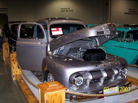 1979 Ford F-150 - Customized 1951 Ford F-1 pickup truck on display at an indoor event, with another classic car in the background.