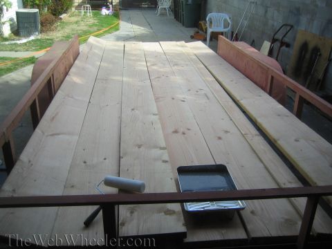 1987 Suzuki Samurai - A trailer is filled with wood planks, ready for a project, with painting supplies nearby.