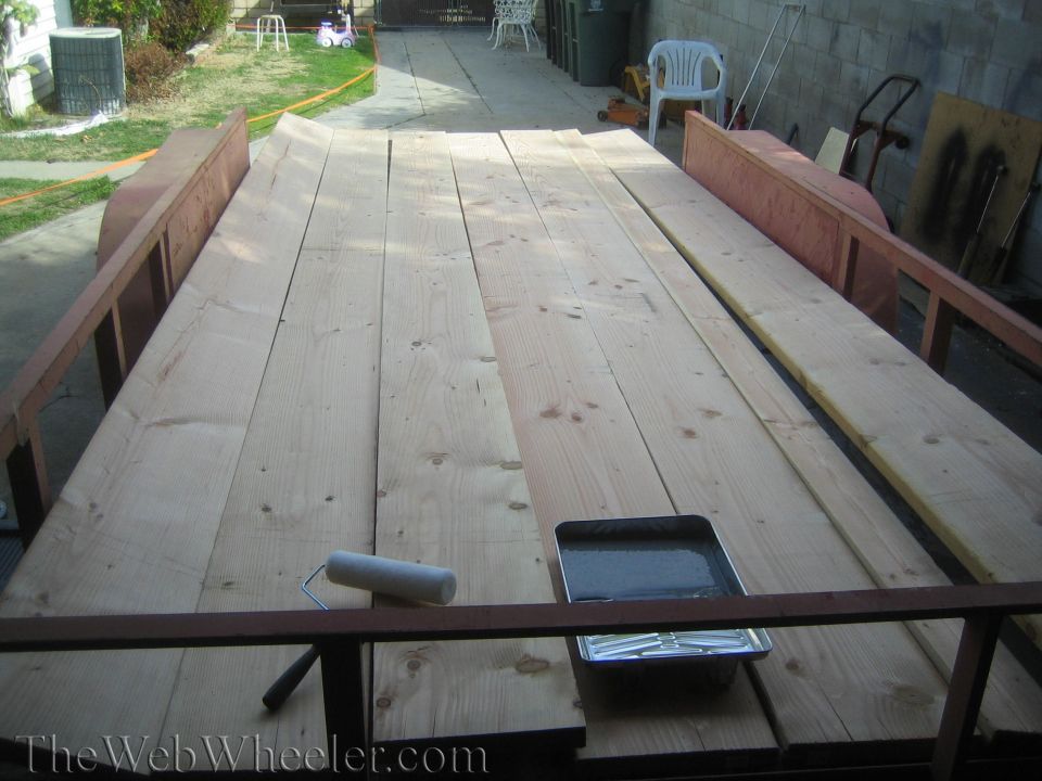 Trailer loaded with lumber, a paint roller, and a tray of paint