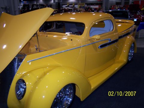 1979 Ford F-150 - A bright yellow custom truck with its hood raised is displayed indoors, lines and chrome accents.