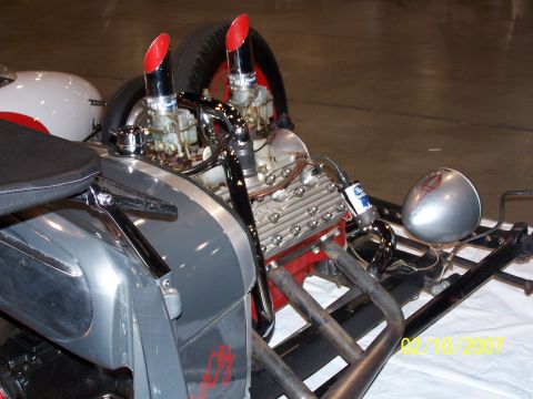 1979 Ford F-150 - A custom hot rod engine is displayed with its chrome exhaust pipes and dual carburetors visible.