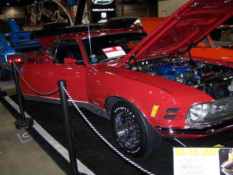 1979 Ford F-150 - Red 1970 Ford Mustang Mach 1 on display at an indoor car show.