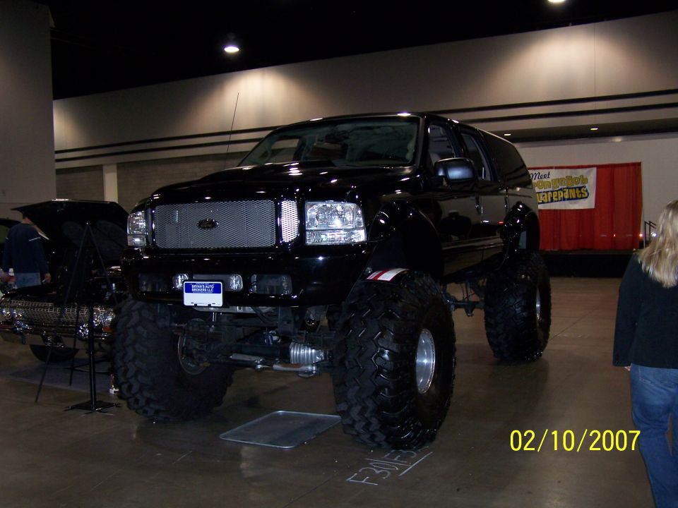 Black lifted SUV with large tires and custom grille