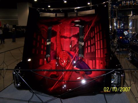 1979 Ford F-150 - This car hood features a custom airbrushed Spiderman design with a city skyline and red lighting.