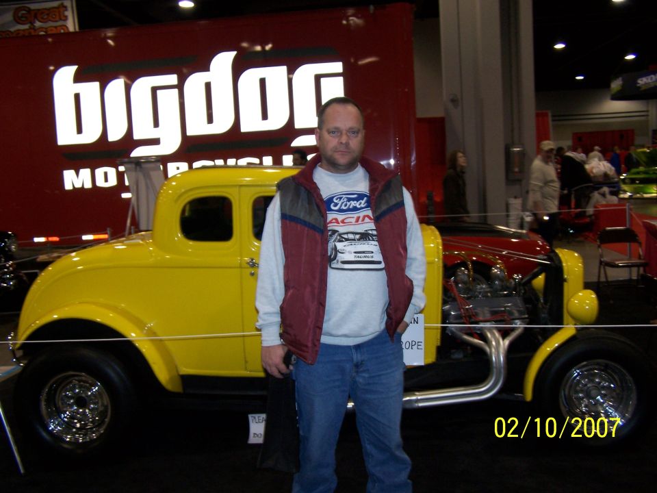 Yellow hot rod coupe with exposed engine and chrome wheels