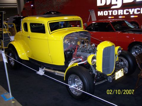 1979 Ford F-150 - A bright yellow coupe with a powerful engine on display at an indoor event.