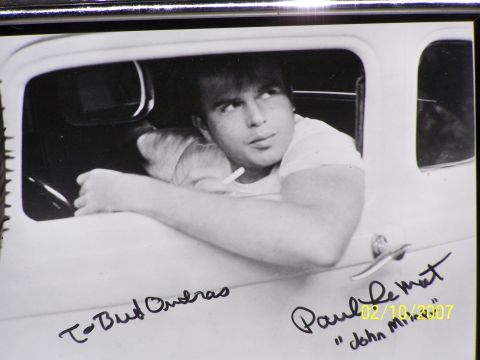 1979 Ford F-150 - A man poses inside a vintage car, which is signed by Paul Le Mat and "John M."