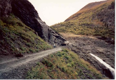 1979 Ford Bronco - A vehicle navigates a treacherous mountain pass with a sheer drop on one side.