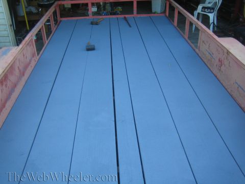 1987 Suzuki Samurai - The bed of a trailer, painted blue, with two hammers and a mallet visible on the planks. The Web Wheeler.com watermark is present.