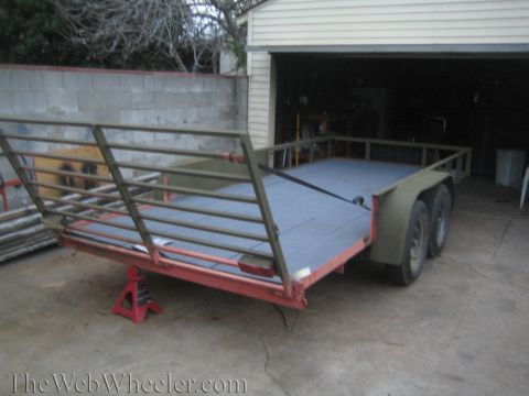 1987 Suzuki Samurai - A utility trailer is shown in a driveway, parked in front of an open garage door.