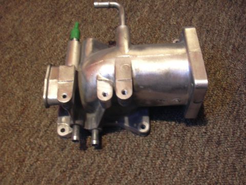 1996 Ford Crown Victoria - Aluminum intake manifold part with green sensor and metal tubes, likely for a vehicle.