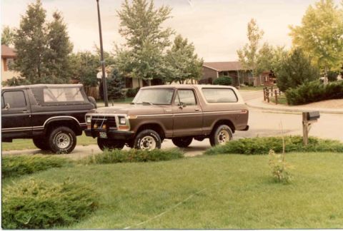 1979 Ford Bronco - Two SUVs, a brown Ford Bronco and a black one, are parked in a residential area.