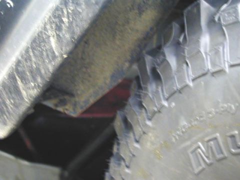 1979 Ford Bronco - A close-up view of a vehicle's tire and fender, showing some text on the tire sidewall.