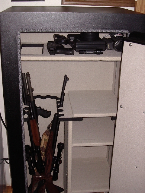 1985 Ford Bronco - Interior view of a gun safe containing multiple firearms, including rifles and handguns.