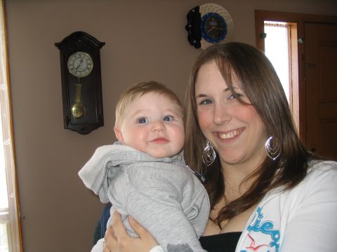 1993 Ford Taurus - A woman smiles while holding a baby in front of a wall clock.