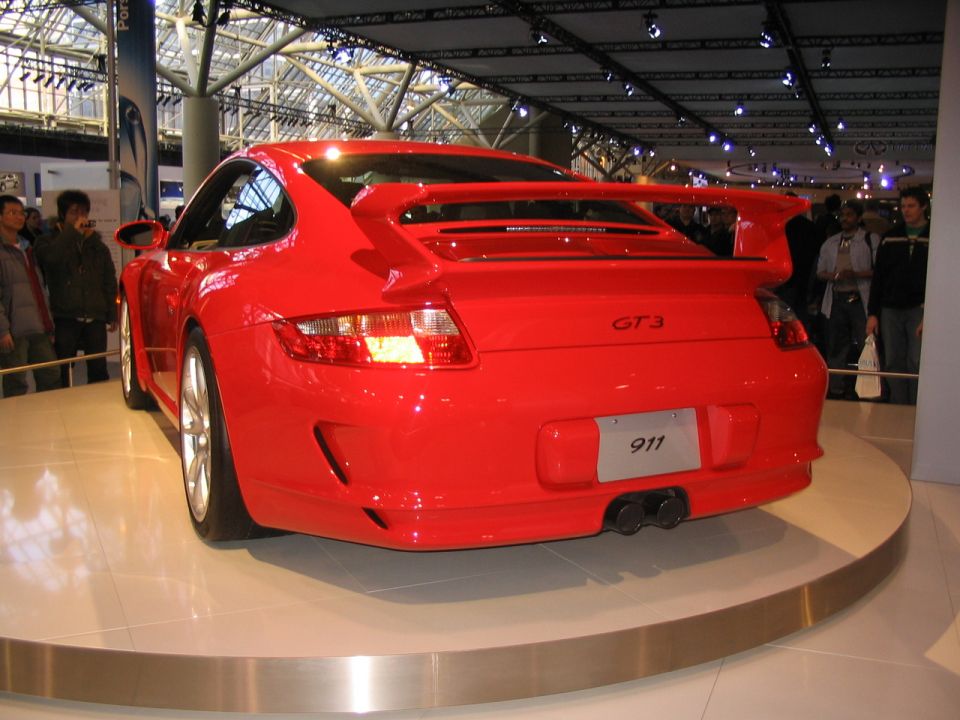 Red Porsche 911 GT3 with large rear spoiler and dual exhaust pipes