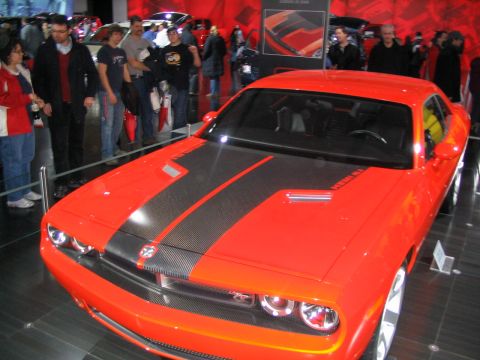 1993 Ford Taurus - Orange Dodge Challenger on display at an auto show.