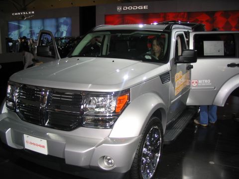 1993 Ford Taurus - A silver Dodge Nitro SUV is displayed with its doors open, likely at an auto show, with Dodge branding visible.