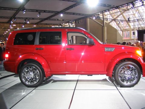 1993 Ford Taurus - A red SUV is displayed indoors with bright lighting and a reflective floor.