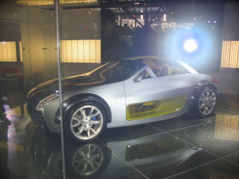 1993 Ford Taurus - A silver concept car with a unique design is showcased on a reflective floor.