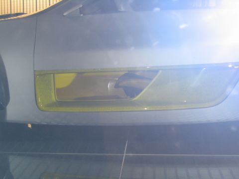 1993 Ford Taurus - Close-up of a car's headlight assembly, showing yellow trim and the internal light housing.