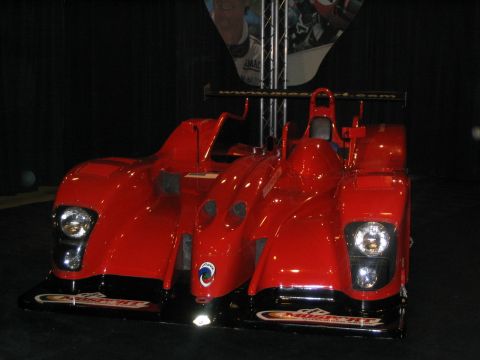 1993 Ford Taurus - A red race car with a low profile and aerodynamic design is displayed indoors.