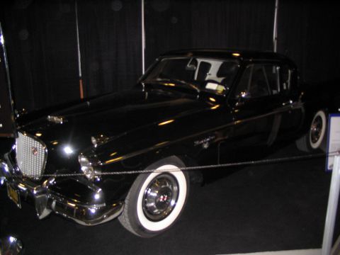 1993 Ford Taurus - A classic black coupe with distinctive chrome accents and whitewall tires is displayed indoors.