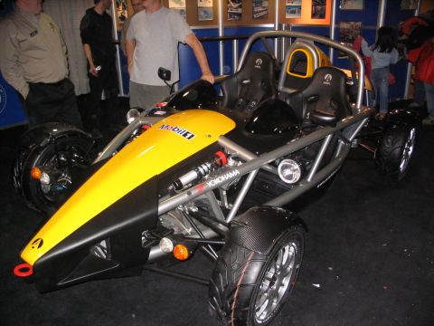 1993 Ford Taurus - An open-wheel sports car with a yellow nose cone and black accents is displayed indoors.