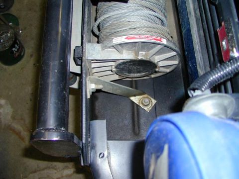 1979 Ford Bronco - A winch and its cable are shown mounted on a bracket, with a blue component in the foreground.