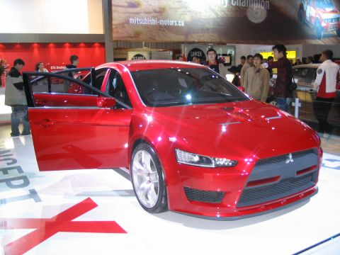 1993 Ford Taurus - A red Mitsubishi Lancer Evolution is displayed with its doors open at an auto show.