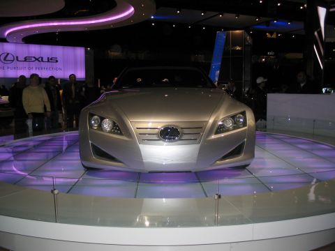 1993 Ford Taurus - Lexus concept car on display at an auto show, with "The Pursuit of Perfection" slogan visible.
