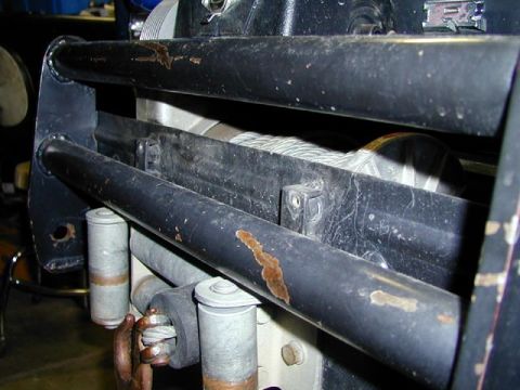 1979 Ford Bronco - Close-up of a vehicle's winch and bumper assembly, showing the steel cable and mounting hardware.