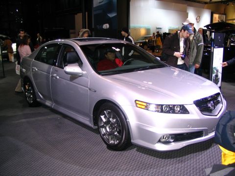 1993 Ford Taurus - A silver sedan is shown at an auto show with people looking at it.