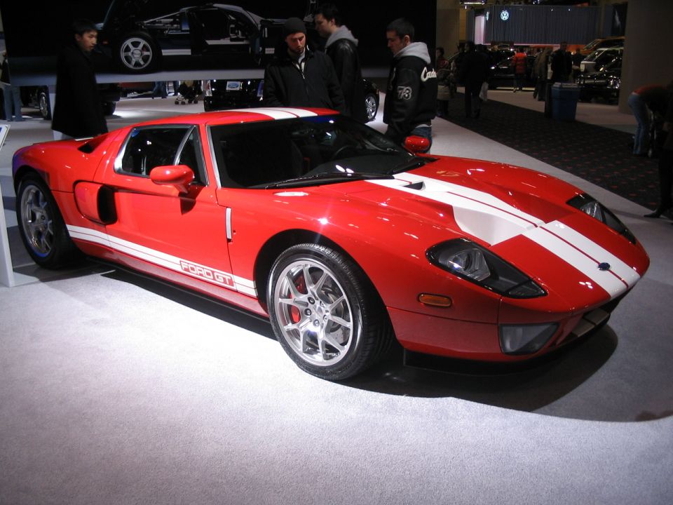 Red Ford GT sports car with white racing stripes on the hood and sides. Text on the side reads 'FORD GT'