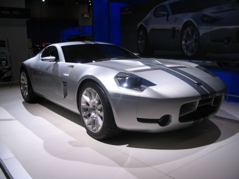 1993 Ford Taurus - A silver Ford Shelby GR-1 concept car is shown at an auto show with another vehicle in the background.