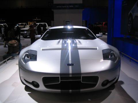 1993 Ford Taurus - A white Ford GT with grey racing stripes is displayed at an auto show.